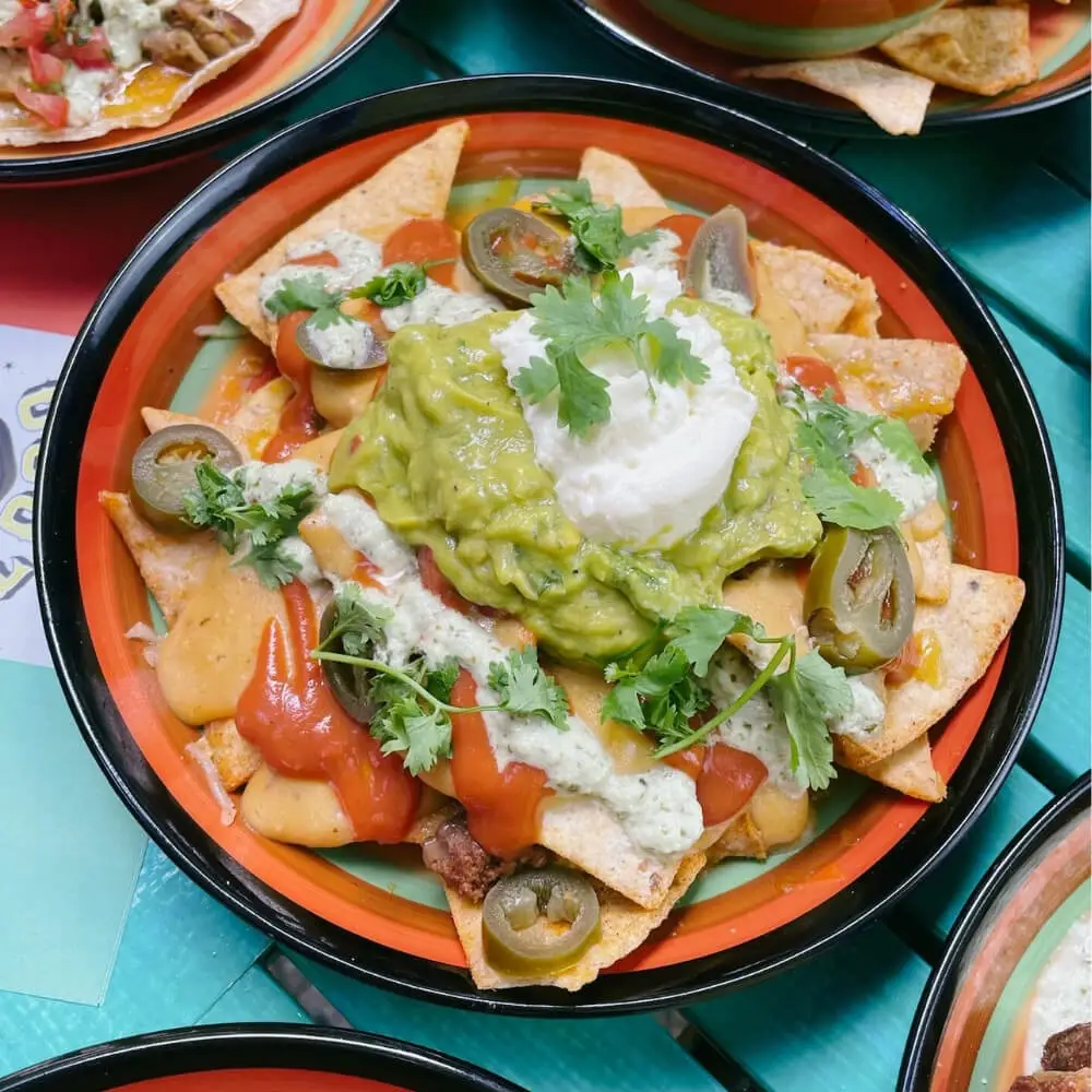 A large platter of loaded nachos, perfect for sharing at the beach.